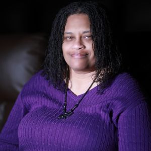 SA, director of FAMILY TIES. Black woman with medium long hair in purple top.